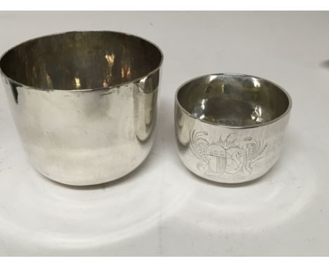 An early 18th century silver cup engraved with a family coat of arms the silver mark incorporating Britannia.possible London 