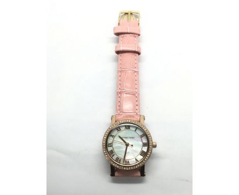 A ladies Michael Kors watch with mother of pearl effect dial and pink leather strap.
