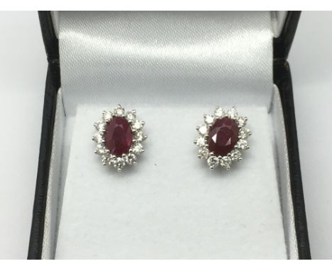 A pair of 18ct white gold studs set with a central oval ruby and diamond clusters, rubies approx 1.93ct, diamonds approx 0.75