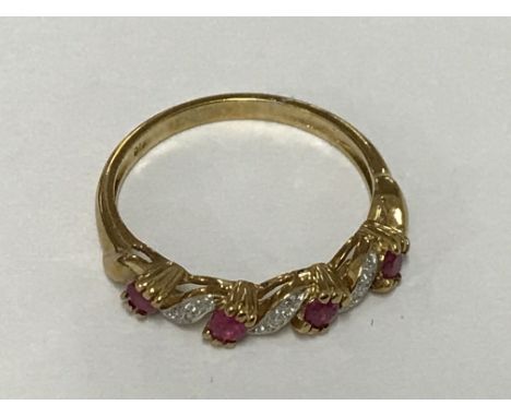 A ruby and diamond half hoop ring in 9ct gold. Ring size M