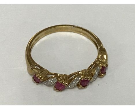 A ruby and diamond half hoop ring in 9ct gold. Ring size M