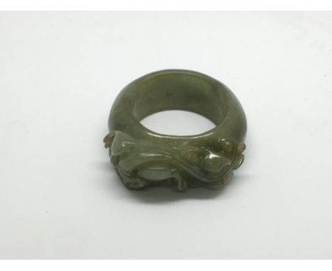 A carved jade ring depicting a mythical beast, approx size T-U.
