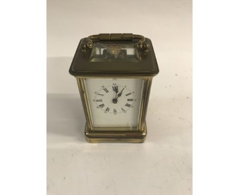 A brass cased carriage clock the dial with Roman numerals.