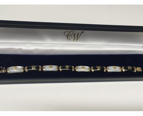 A 9ct gold bracelet set with onyx and mother of pearl.