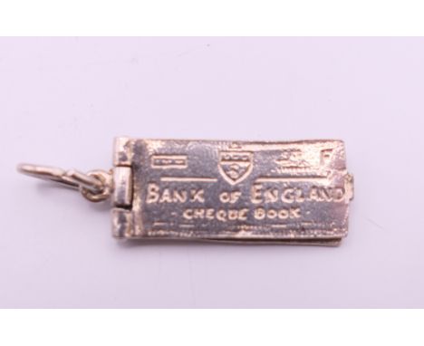 A silver Bank of England cheque book charm. 2.5 cm long.