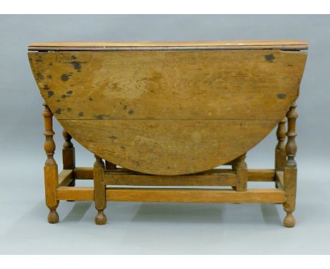 An antique oak gate leg table. 108 cm long.