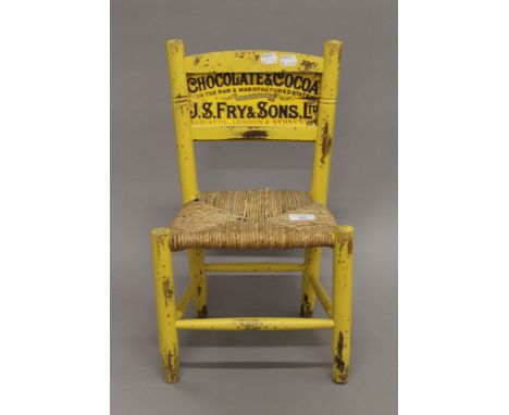 A small yellow painted child's chair, the back inset with an advertising print for J S Fry &amp; Son. 48 cm high.