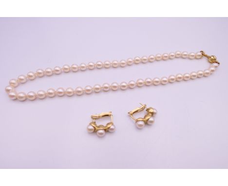 A suite of 18 K gold mounted pearl jewellery, comprising necklace and earrings. The necklace 48 cm long.