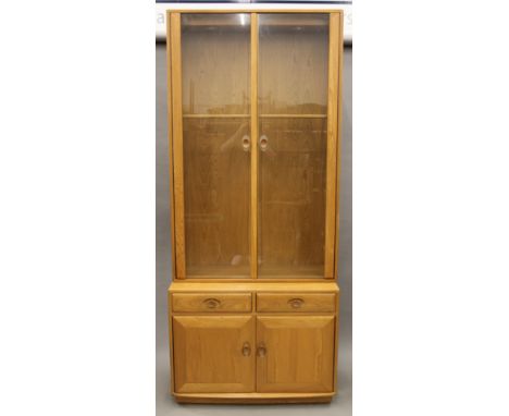 An Ercol blonde oak glazed display cabinet. 213 cm high x 91 cm wide.  