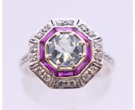 A 9 ct white gold Art Deco style ruby, aquamarine and diamond ring. 13 mm x 13 mm. Ring size M/N. 2.7 grammes total weight.
