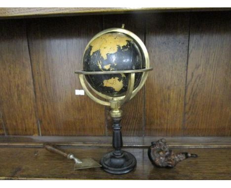 A small Phillips Graphic globe on a brass and ebonized wooden stand, a Chinese composition tobacco pipe and a wooden handled 