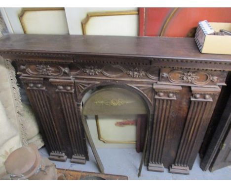 A Portuguese carved wooden breakfront fire surround with floral ornament and fluted pillars, 46" h, 58" w 