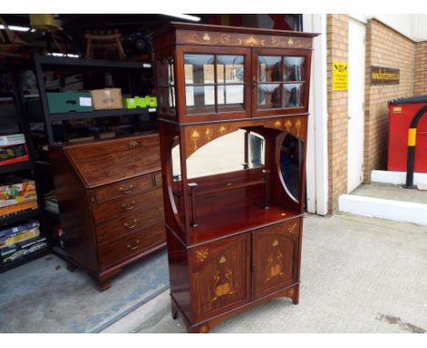 An early 20th century Art Nouveau Liberty style marquetry inlaid mahogany side cabinet of tall and slender proportions, cushi