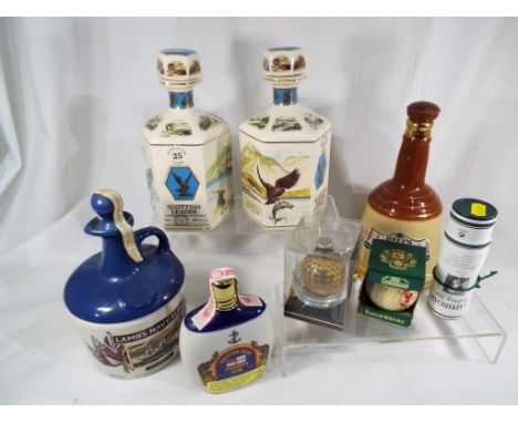 A 750 ml decanter of Lamb's Navy Rum, 200 ml flask of Pusser's Navy Rum, 26.5 oz decanter of Bell's Whisky, a miniature bottl