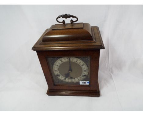 A good quality walnut cased English bracket style mantel clock, bell top case surmounted by brass handle, opening glazed door