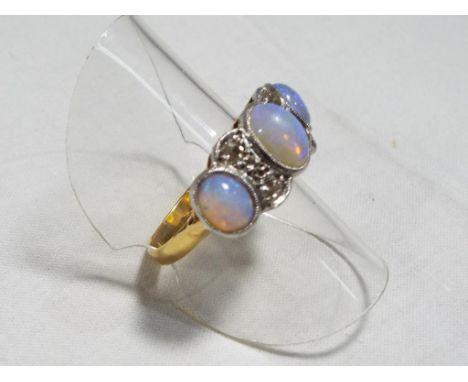 An antique opal and diamond dress ring set with three Cabochon opals and four old cut diamonds, presumed 18 carat gold, size 