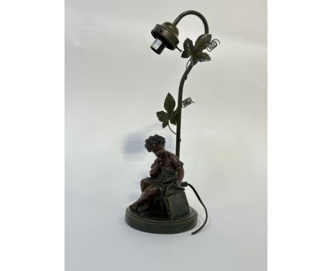 An Art Nouveau style spelter table lamp marked  A.Moreau copy of a child opening a briefcase to base.  (h- 45cm)