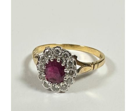 An 18ct gold ruby and diamond cluster earring mounted in white gold setting, stone approximately 0.7ct with surround of twelv