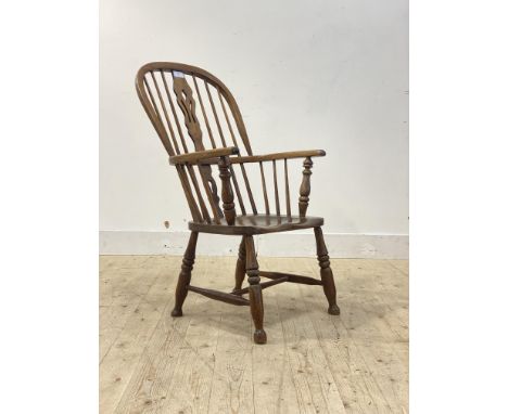 A 19th century ash and fruit wood Windsor armchair, double hoop, spindle and splat back over saddle seat, raised on turned su