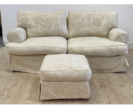 A traditional two seat sofa, upholstered in a fitted white damask cover, raised on turned bun supports, retailed by John Lewi