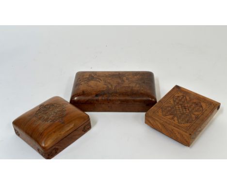 A trio of cigarette boxes, one with olive wood with hatched cross design, an Eastern walnut wood box with carved bird and fis