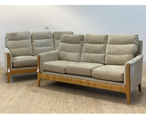 A pair of three seat sofas, each with squab cushions upholstered in beige chenille fabric, with elm show frame, raised on tap