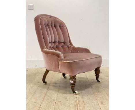 A Victorian button back slipper chair, upholstered in pink velvet, raised on turned supports with castors, H81cm