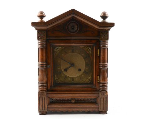 Late Victorian walnut and beechwood mantel clock, architectural pediment with turned spindles, square brass dial, the movemen
