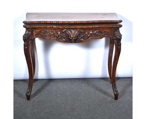 German carved oak card table, early 20th Century, serpentine outline, the frieze and shoulders carved with masks and foliage,