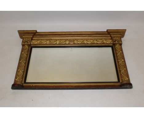 George IV gilt gesso overmantel mirror, the rectangular plate within reeded ebonised slip and cushion surround applied with s