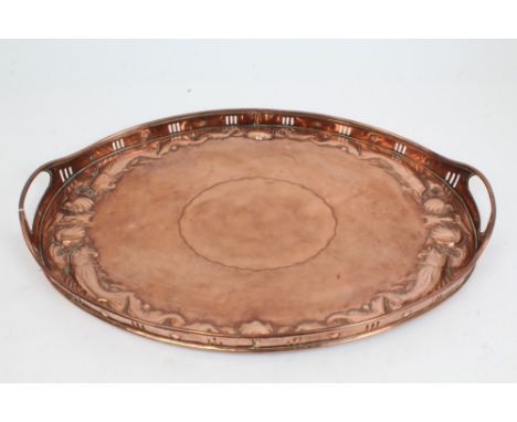 Early 20th century Newlyn copper tray of oval form, the pierced gallery with integral carrying handles, the base with embosse