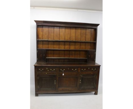 George III oak high dresser, the boarded rack with two enclosed cupboards, the base having three short drawers and two fielde
