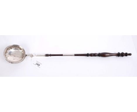 George IV silver toddy ladle of circular form, with embossed floral decoration, silver scroll handle with turned lignum vitae