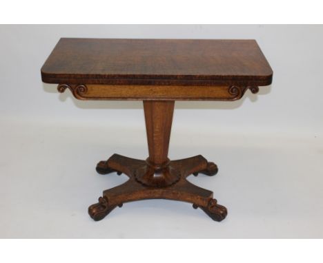 William IV pollard oak card table with D-shaped foldover top, baize-lined to the underside on scroll frieze on octagonal colu