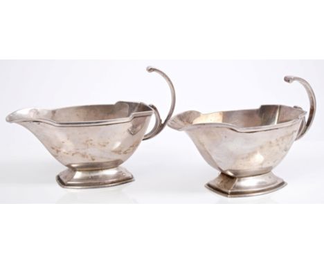 Pair 1930s silver sauce boats of faceted form, in the Art Deco style, with open scroll handles, on flared bases (Birmingham 1