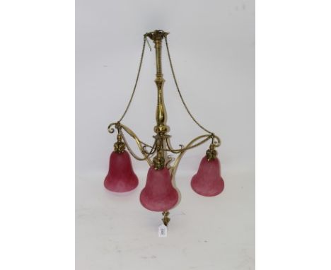 Victorian-style brass ceiling light with central knopped column issuing three rising scrolling arms terminating in pendant dr