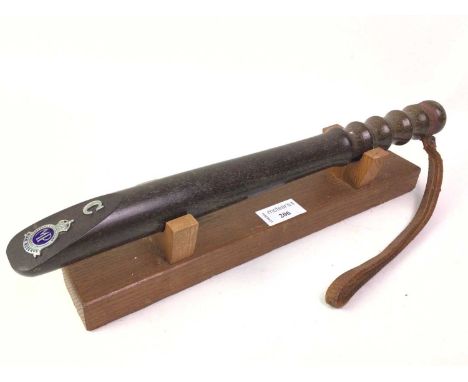 WOODEN TRUNCHEON, mounted with an enamel MP War Reserve badge, with leather hand strap, on stand40cm long