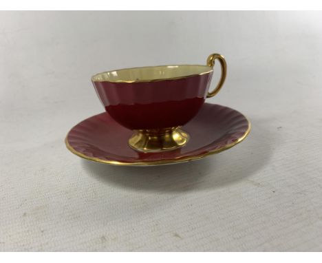 AN AYNSLEY SIGNED J.A. BAILEY OBAN SHAPED TEACUP AND SAUCER RUBY RED WITH A STUNNING FLORAL BOUQUET 