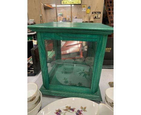 A GREEN WOODEN DISPLAY CABINET WITH A GLASS SHELF 