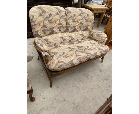 AN ERCOL TWO SEATER SETTEE ON SPINDLE FRAME WITH KICK OUT LEGS 