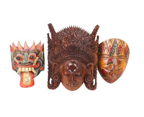 Three East Asian carved wood masks. From Bali and Java, two with painted and stained decoration, largest H30cm.