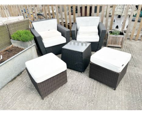 A contemporary rattan suite of garden furniture. Including two armchairs, two  footstools and a table.