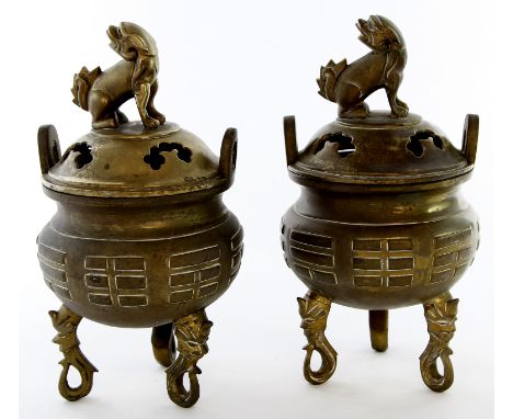A pair of Chinese cast brass censers, early 20th Century 
Raised on tripod supports with cast mask terminals, the rounded bom