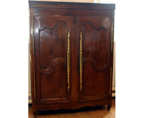 An 18th/19th Century French oak Armoire 
The moulded over-hanging cornice above two shaped panelled doors enclosing a single 