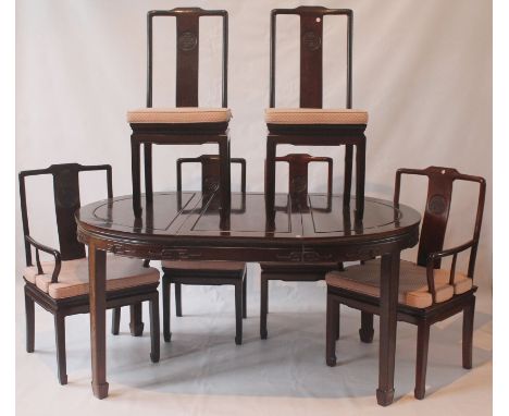A contemporary Chinese huanghuali style dining table and chairs
The oval form dining table including extra leaf, the external