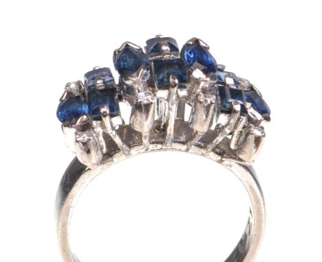 A sapphire and diamond set cocktail ring, circa 1970
Set with a broad line of marquise and baguette cut sapphires with round 