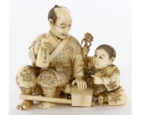 A Japanese ivory okimono figure group, Meiji period (1868-1912)
The well carved and stained group, modelled as a father and s