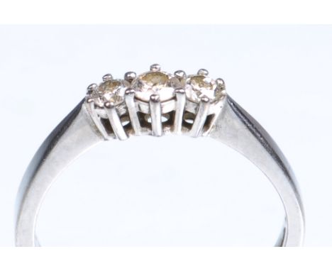 A 18ct white gold diamond set three stone ring
The three round brilliant cut diamonds claw set to tapering shoulders and plai