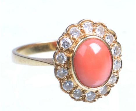 An 18ct gold diamond and coral set cluster ring
The oval cabochon pink coral collet set to a border of fourteen round brillia