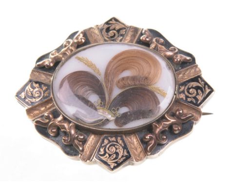 A Victorian mourning brooch 
The central oval window displaying hair, wire and bead work, to a border of black enamel and app